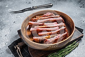 Homemade Smoked Barbecue Pork Ribs in wooden plate ready for eat. Gray background. Top view