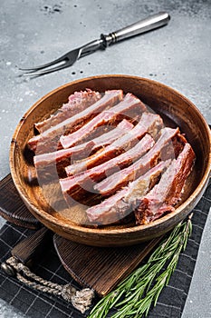 Homemade Smoked Barbecue Pork Ribs in wooden plate ready for eat. Gray background. Top view