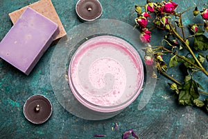 Homemade soap with cream in bowl and dried rose flowers