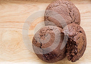 Homemade soft dark chocolate brownie cookies placed on a wooden plate. Close Up cookies are bitten. Look good and delicious