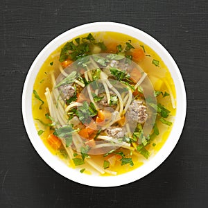 Homemade Sopa a La Minuta in a white bowl on a black surface, top view. Close-up