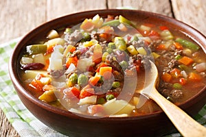 Homemade soup with ground beef and vegetable mix close-up in a b