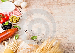 Homemade spaghetti pasta with quail eggs with bottle of tomato sauce and cheese on wooden background. Classic italian village food