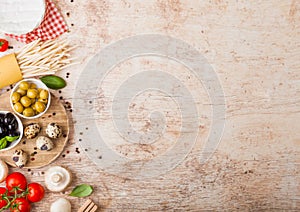 Homemade spaghetti pasta with quail eggs with bottle of tomato sauce and cheese on wooden background. Classic italian village food