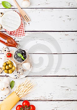 Homemade spaghetti pasta with quail eggs with bottle of tomato sauce and cheese on wooden background. Classic italian village food