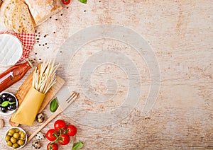 Homemade spaghetti pasta with quail eggs with bottle of tomato sauce and cheese on wooden background. Classic italian village food