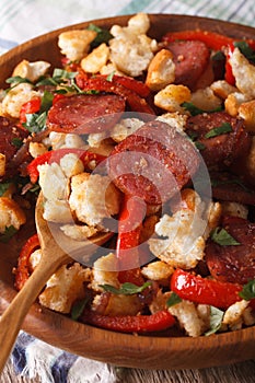 Homemade Spanish migas with chorizo close-up on a plate. vertica