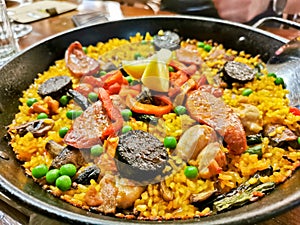 Homemade Spanish Paella with black chorizo sausages  served in black pan