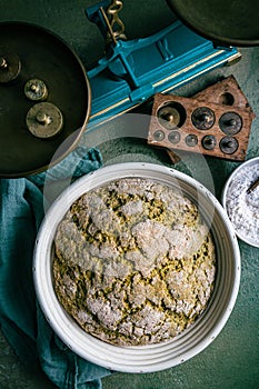 Homemade spelt bread with herbs and wild garlic, process of raising dough in a special basket