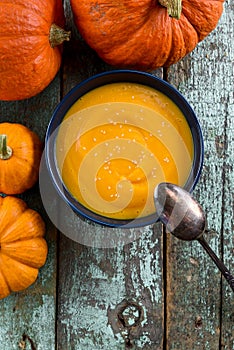 Homemade spicy vegan pumpkin soup with sesame seeds in blue bowl