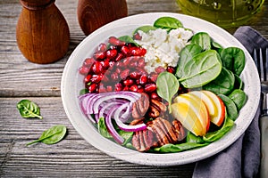 Homemade spinach, apple, pecan, red onion salad with goat cheese and pomegranate