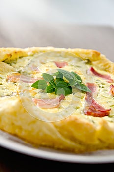 Homemade Spinach and Bacon Egg Quiche in a pie crust on wood board. French cuisine flat design