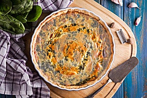 Homemade spinach french pie quiche lorraine on wooden board top view photo