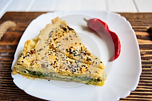 Homemade spinach french pie on a white wooden board