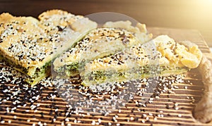 Homemade spinach french pie on a white wooden board