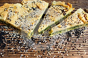 Homemade spinach french pie on a white wooden board