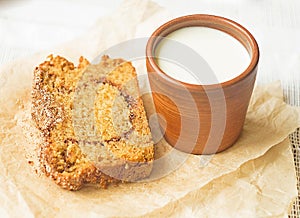 Homemade sponge cinnamon cake on white table, soft and moist dessert with milk. Homemade bakery concept for background