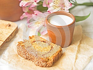 Homemade sponge cinnamon cake on white table, soft and moist dessert with milk. Homemade bakery concept for background
