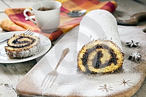 Homemade sponge roll with liquid chocolate on a wooden table