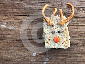 Homemade square bars of Rice Crispy Decorate Christmas reindeer on the wooden table