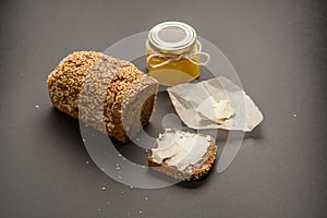 Homemade square bread made from gluten-free flour with sesame seeds. piece of bread with butter and bee honey. Close-up. concept