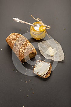 Homemade square bread made from gluten-free flour with sesame seeds. piece of bread with butter and bee honey. Close-up. concept