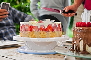 Homemade Strawberry Cake with Unrecognizable People in Background