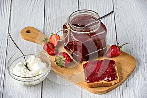 Homemade strawberry jam in a glass jar with Creme Fraiche