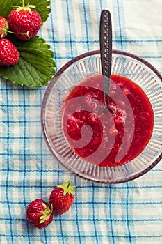 Homemade strawberry jam (marmelade). glass bowl with hot jam and fresh strawberries photo