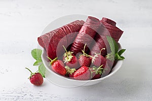 Homemade strawberry pastille with fresh strawberries on a light blue background