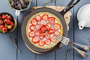 Homemade strawberry pie with whipped cream in cast iron skillet