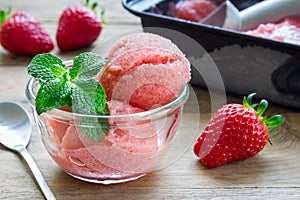 Homemade strawberry sorbet in glass on wooden table