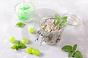 Homemade sugar scrub with chopped mint leaves, mint candies and essential mint