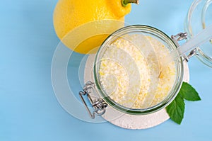 Homemade sugar scrub with olive oil, essential lemon oil and lemon peel. Diy cosmetics. Top view, copy space.
