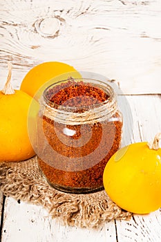 Homemade sugar scrub with a pumpkin on a wooden background