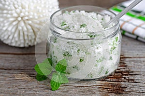 Homemade sugar scrub with vegetable oil, chopped mint leaves and essential mint oil
