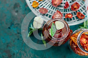 Homemade sun dried tomatoes with herbs, garlic in olive oil in a glass jar