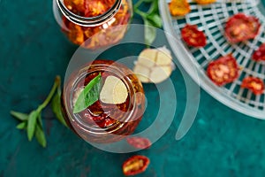 Homemade sun dried tomatoes with herbs, garlic in olive oil in a glass jar