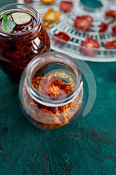 Homemade sun dried tomatoes with herbs, garlic in olive oil in a glass jar