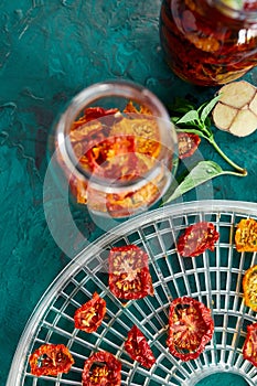 Homemade sun dried tomatoes with herbs, garlic in olive oil in a glass jar