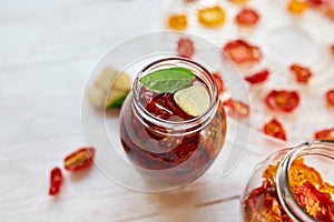 Homemade sun dried tomatoes with herbs, garlic in olive oil in a glass jar