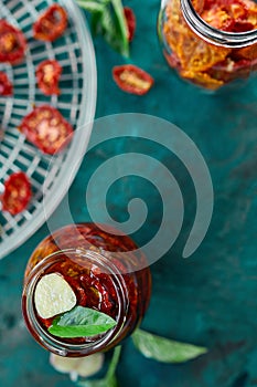 Homemade sun dried tomatoes with herbs, garlic in olive oil in a glass jar