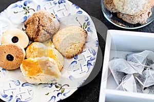 Homemade sweet cookies for afternoon snack, traditional home-made artisan pastry. decorated plate of biscuits on a black stone.