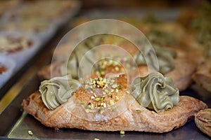 Homemade sweet pastry cannolo sfoglie filled with almond, pistachio, lemon, vanilla, chocolate cream on food market in Italy photo