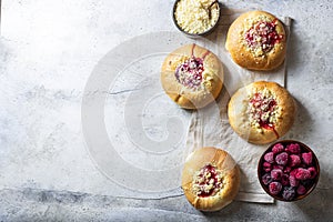 Homemade Sweet Yeast Buns filled with Berry and with crumble. Concrete bsckground