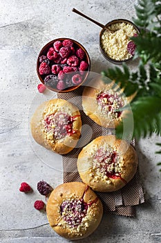 Homemade Sweet Yeast Buns filled with Berry and with crumble. Concrete bsckground