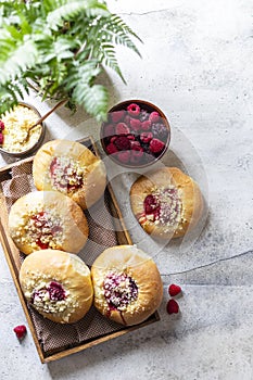 Homemade Sweet Yeast Buns filled with Berry and with crumble. Concrete bsckground