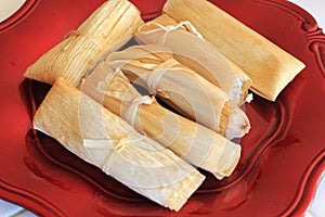 Homemade tamales on a red plate