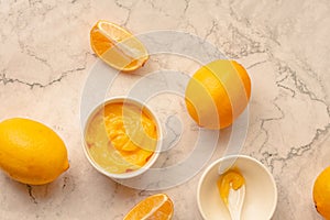 Homemade tangy lemon curd decorated with fresh fruit on marble background.Top view. Copy space for text