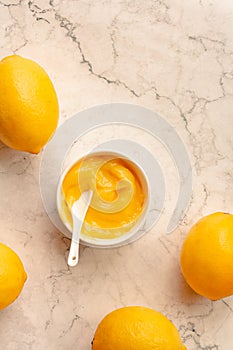 Homemade tangy lemon curd decorated with fresh fruit on marble background.Top view. Copy space for text